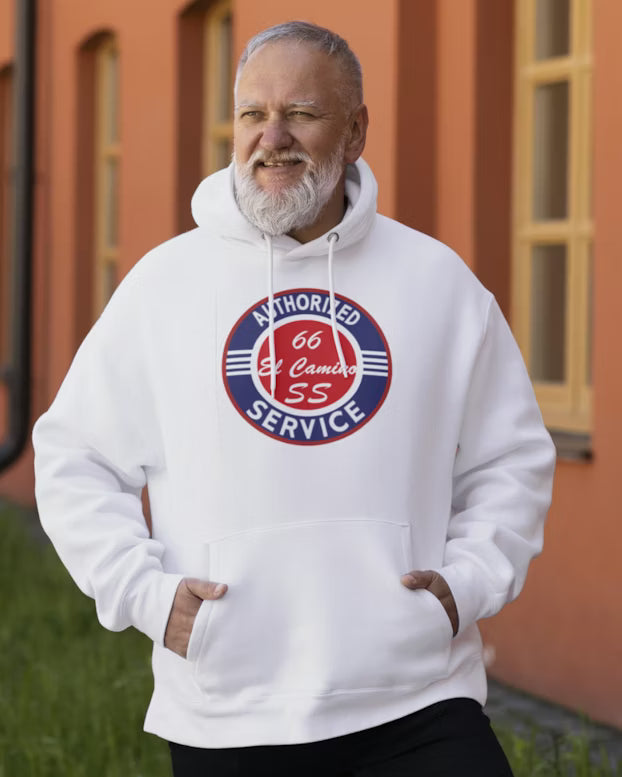 Man wearing a white hoodie with a logo in front of an orange building.
